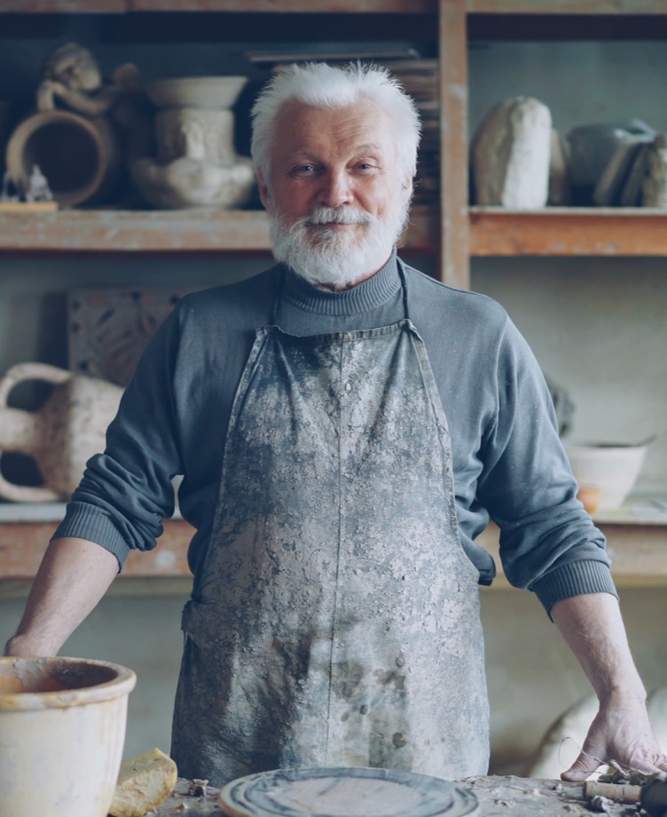 A sole trader maker smiling in his workshop